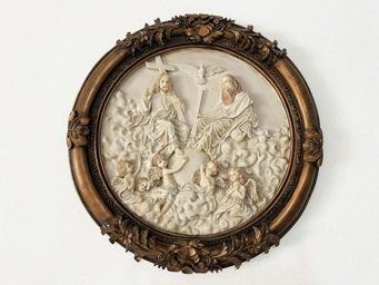 Relief sculpture of Jesus Christ and God the Father on clouds, surrounded by angels and a dove, in an ornate circular frame.